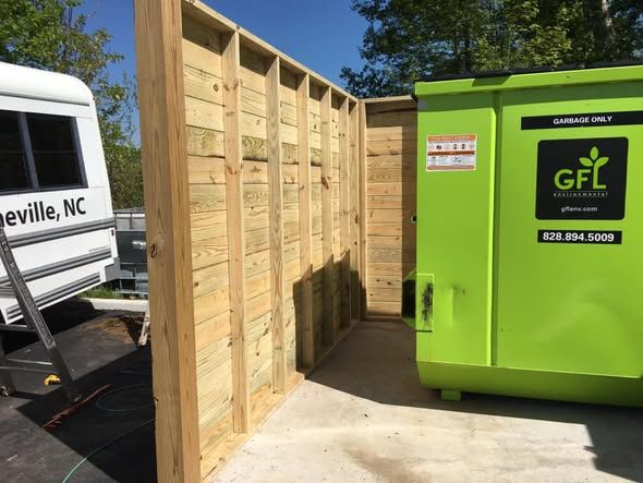 Wooden enclosure built around a dumpster pad