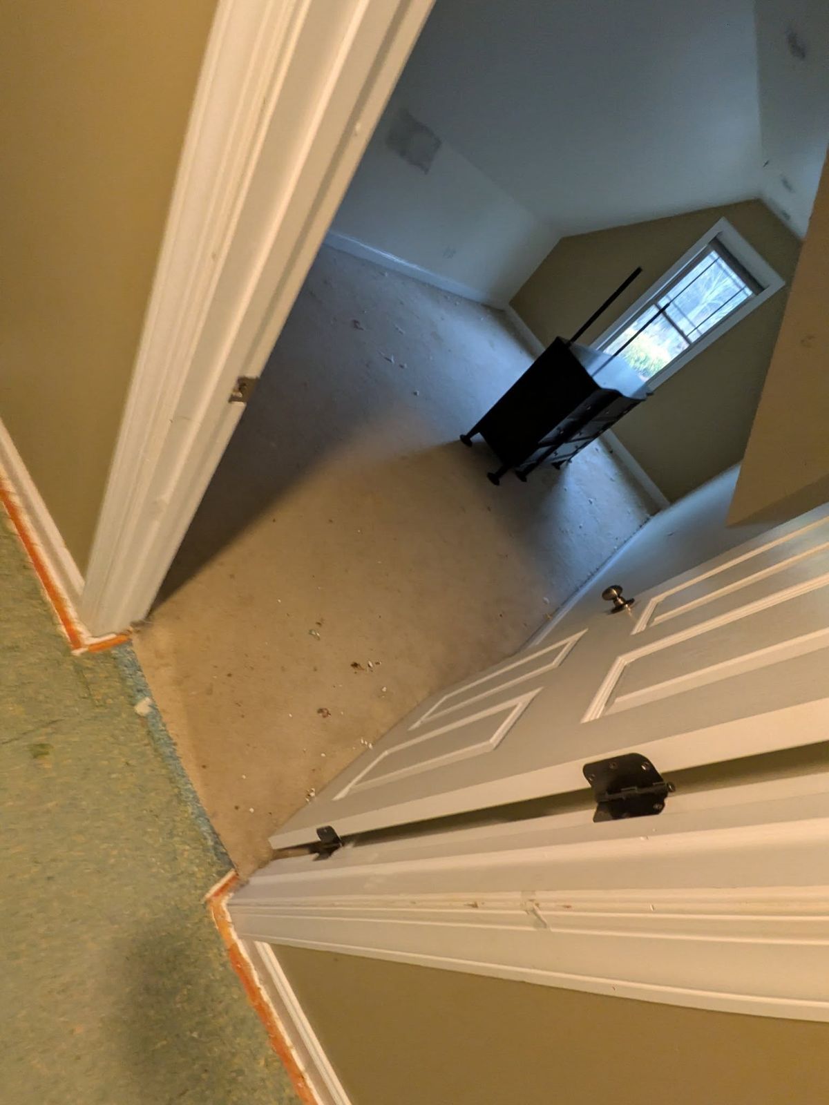 Doorway and bedroom with old carpet before flooring work