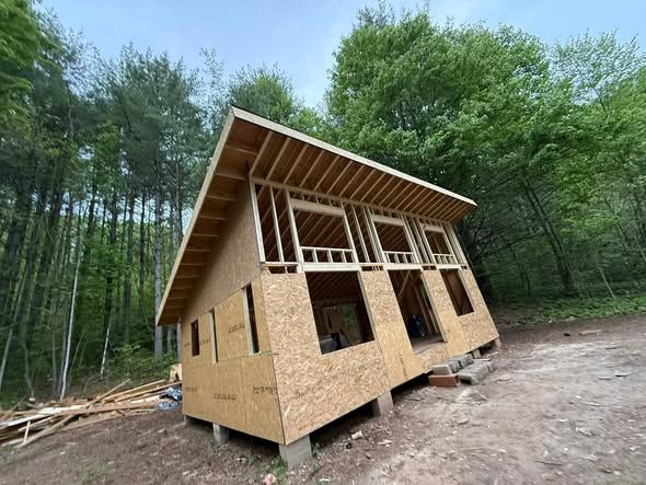 Shed-roof cabin with rafters and sheathing