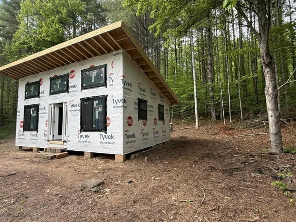 Small shed-roof cabin wrapped and ready for siding