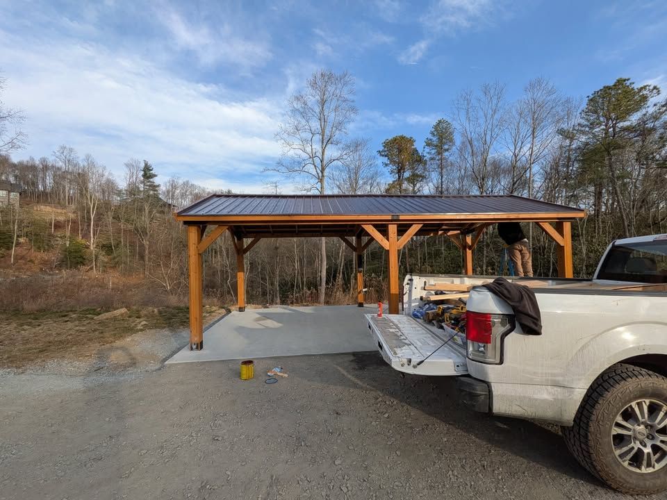 Timber-frame pavilion with a metal roof built over a concrete slab